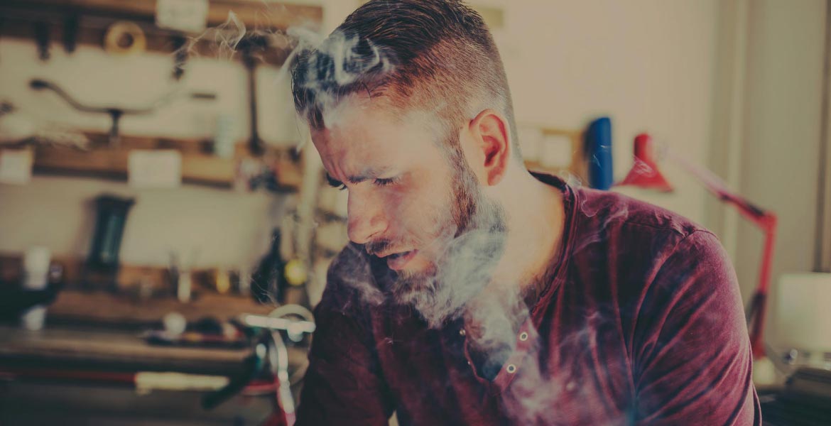 Man Sitting with Smoke Over Face